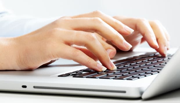 Hands of business woman with laptop computer keyboard.