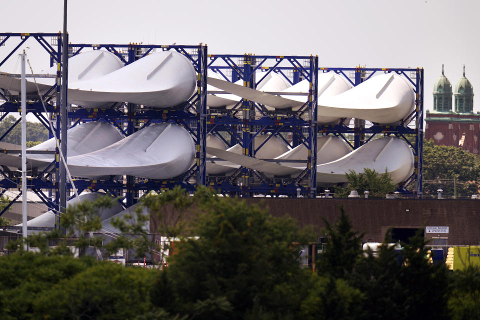 Giant wind turbine blades for the Vineyard Winds project are stacked on racks in the harbor, Tuesday, July 11, 2023, in New Bedford, Mass. (AP Photo/Charles Krupa)