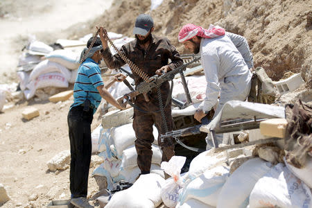 Rebel fighters from the Ahrar al-Sham Islamic Movement prepare their weapons in Jabal al-Arbaeen, which overlooks the northern town of Ariha, one of the last government strongholds in the Idlib province May 26, 2015. REUTERS/Khalil Ashawi/Files