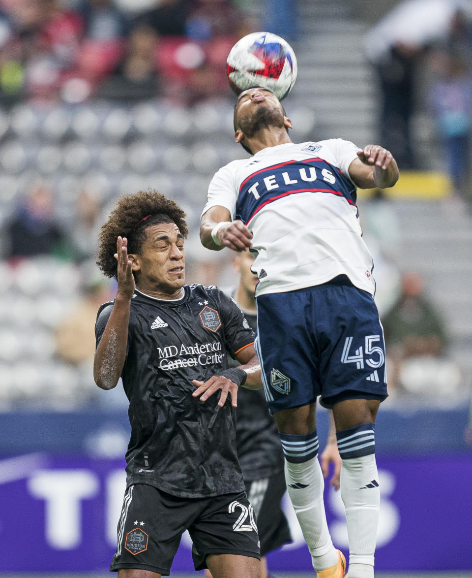 Vancouver Whitecaps' Pedro Vite gets his head on the ball next to Houston Dynamo's Coco Carrasquilla during the first half of an MLS soccer match Wednesday, May 31, 2023, in Vancouver, British Columbia. (Rich Lam/The Canadian Press via AP)
