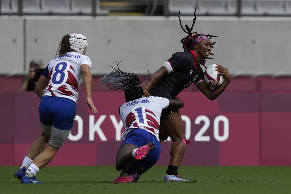 Canada's Charity Williams is tackled by France's Seraphine Okemba, in their women's rugby sevens match at the 2020 Summer Olympics, Friday, July 30, 2021 in Tokyo, Japan. (AP Photo/Shuji Kajiyama)