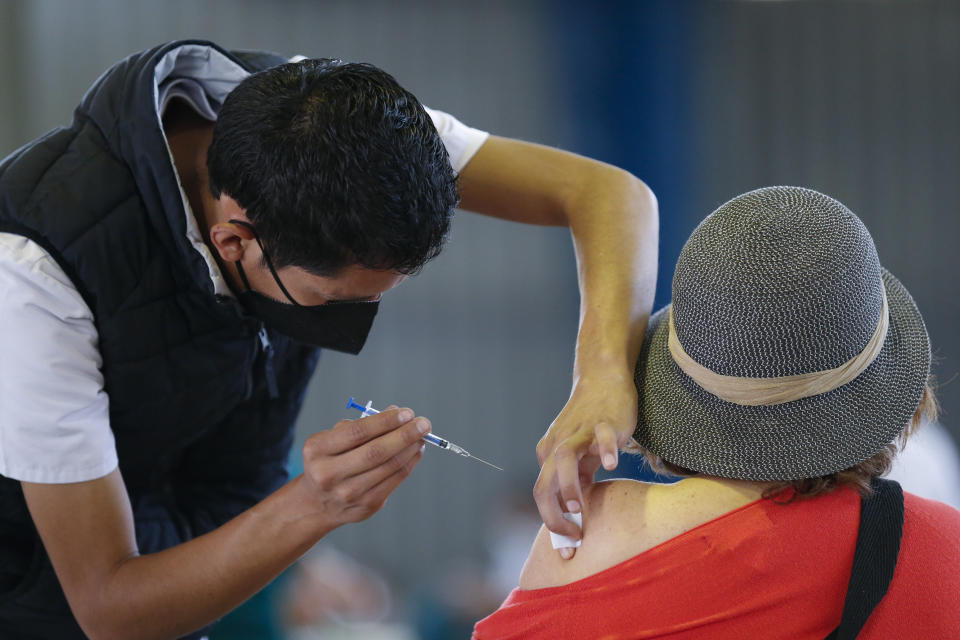 FILE - In this Feb. 24, 2021, file photo, a medical worker injects a woman with a dose of the Russian COVID-19 vaccine Sputnik V at the Palacio de los Deportes, in the Iztacalco borough of Mexico City. Russia’s boast in August that it was the first country to authorize a coronavirus vaccine led to skepticism because of its insufficient testing on only a few dozen people. Now, with demand growing for the Sputnik V, experts are raising questions again, this time over whether Moscow can keep up with all the orders from countries that want it. (AP Photo/Rebecca Blackwell, File)