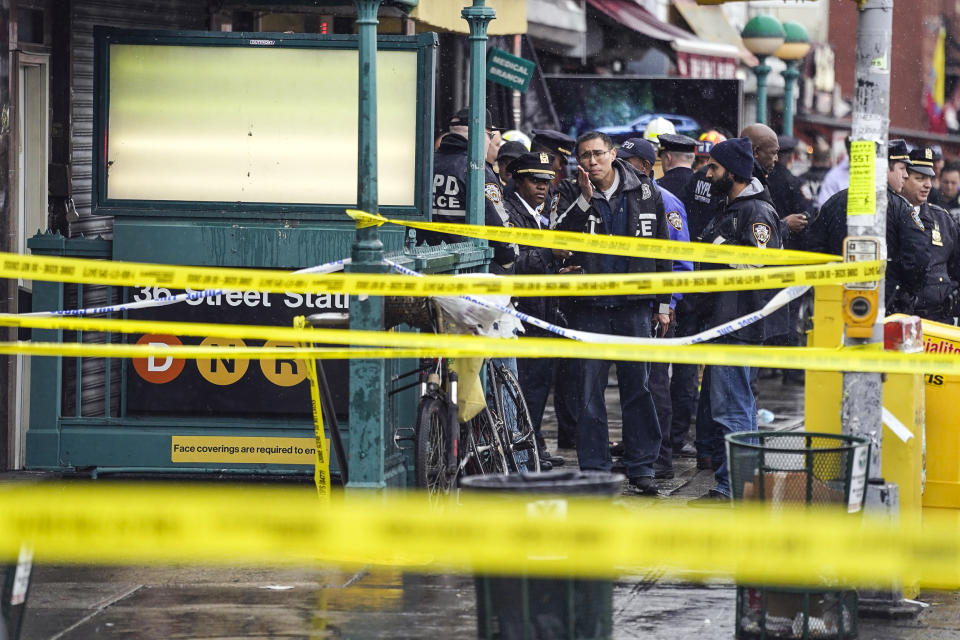 Image: New York City Police Department personnel gather at the entrance to a subway stop in the Brooklyn, N.Y., on April 12, 2022 (John Minchillo / AP)