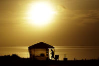 A man sets up his camp along the Indian River Lagoon at sunrise Saturday, May 30, 2020, at Titusville, Fla. as he waits to watch the launch of the SpaceX Falcon 9, with Dragon crew capsule on top of the rocket. Two astronauts are set to fly on the SpaceX Demo-2 mission to the International Space Station scheduled for launch from the Kennedy Space Center in Cape Canaveral, Fla. For the first time in nearly a decade, astronauts will blast into orbit aboard an American rocket from American soil, a first for a private company. (AP Photo/Charlie Riedel)