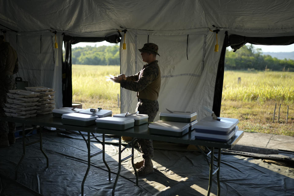 A U.S. soldier prepares meals as the day starts at Lal-lo airport, Cagayan province, northern Philippines Monday, May 6, 2024. The United States and the Philippines, which are longtime treaty allies, have identified the far-flung coastal town of Lal-lo in the northeastern tip of the Philippine mainland as one of nine mostly rural areas where rotating batches of American forces could encamp indefinitely and store their weapons and equipment within local military bases under the Enhanced Defense Cooperation Agreement, or EDCA. (AP Photo/Aaron Favila)