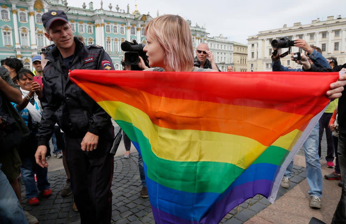 A police officer speaks with a gay rights activist standing with a rainbow flag at Dvortsovaya Square in St. Petersburg, Russia (File photo) (Copyright 2023 The Associated Press. All rights reserved.)