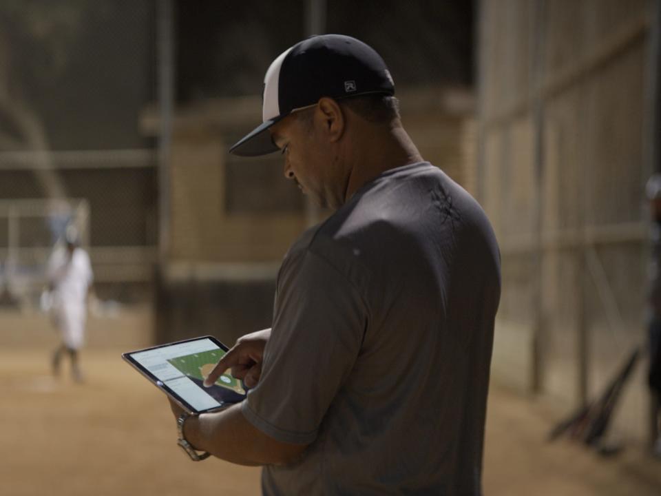 Man at baseball field using GameChanger app