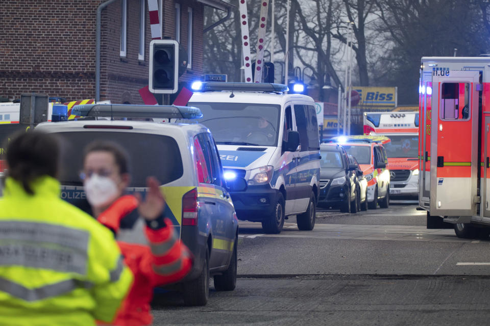 Police and rescue services work at a level crossing at Brokstedt station in Brockstedt, Germany, Wednesday, Jan. 25, 2023. A man stabbed and wounded several people on a train in northern Germany on Wednesday before police detained him, and two of the victims died, German news agency dpa reported. (Jonas Walzberg/dpa via AP)