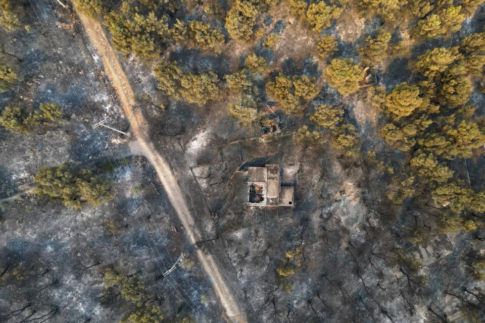 A damaged house is seen inside a burnt forrest in Mandra, west of Athens, Greece, on Wednesday, July 19, 2023. Wildfire evacuations have continued for a third day outside the Greek Capital as a second heat wave hit the Mediterranean country from the west after days of record-high temperatures baked southern Europe. (AP Photo/Thanassis Stavrakis)