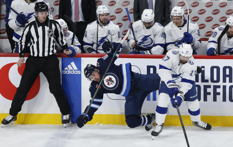 Winnipeg Jets' Nate Schmidt (88) is checked by Tampa Bay Lightning's Alex Killorn (17) during second-period NHL hockey game action in Winnipeg, Manitoba, Friday, Jan. 6, 2023. (John Woods/The Canadian Press via AP)