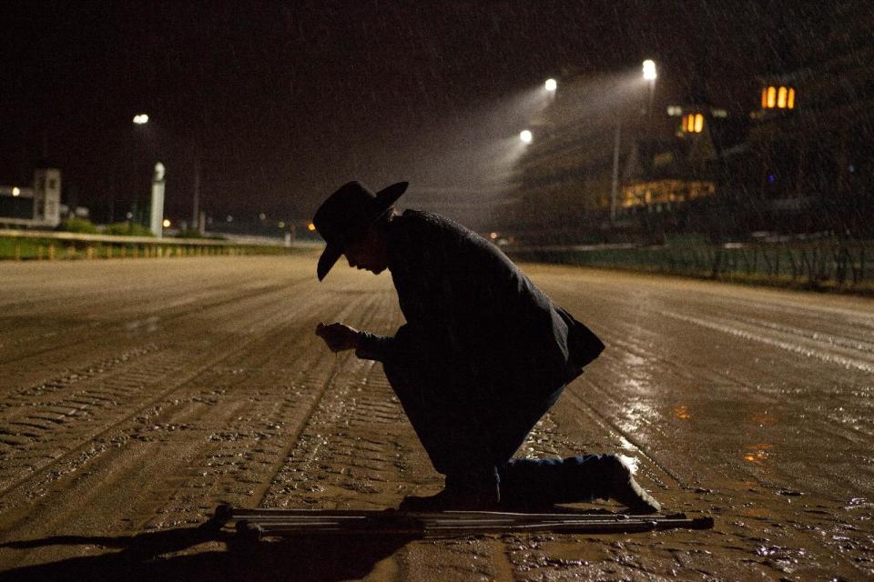 In this Oct. 14, 2012 image provided by Allied-THA, Chip Woolley, played by actor Skeet Ulrich, kneels on the muddy racetrack in a scene from the movie “50-1." (AP Photo/Courtesy of Allied-THA.