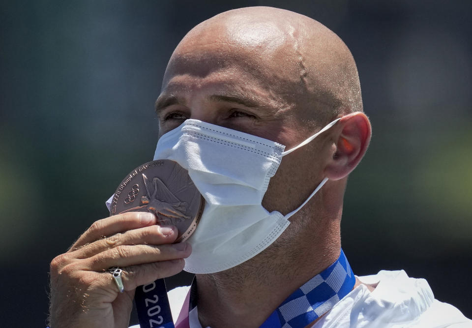 Liam Heath, of Britain, kisses his bronze medal in the men's kayak single 200-meter final at the 2020 Summer Olympics, Thursday, Aug. 5, 2021, in Tokyo, Japan. (AP Photo/Lee Jin-man)