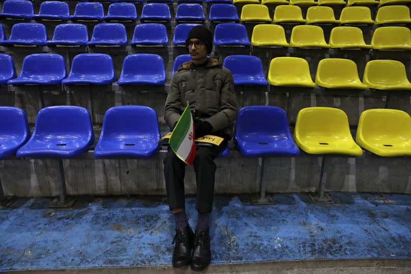 An Iranian man sits in an election campaign rally ahead of the 1 March parliamentary and Assembly of Experts elections, in Tehran, February 2024