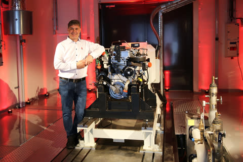 AGCO Power’s Chief Engineering Officer Kari Aaltonen stands in front of a hydrogen combustion engine in the new Clean Energy Laboratory. (Photo: Business Wire)