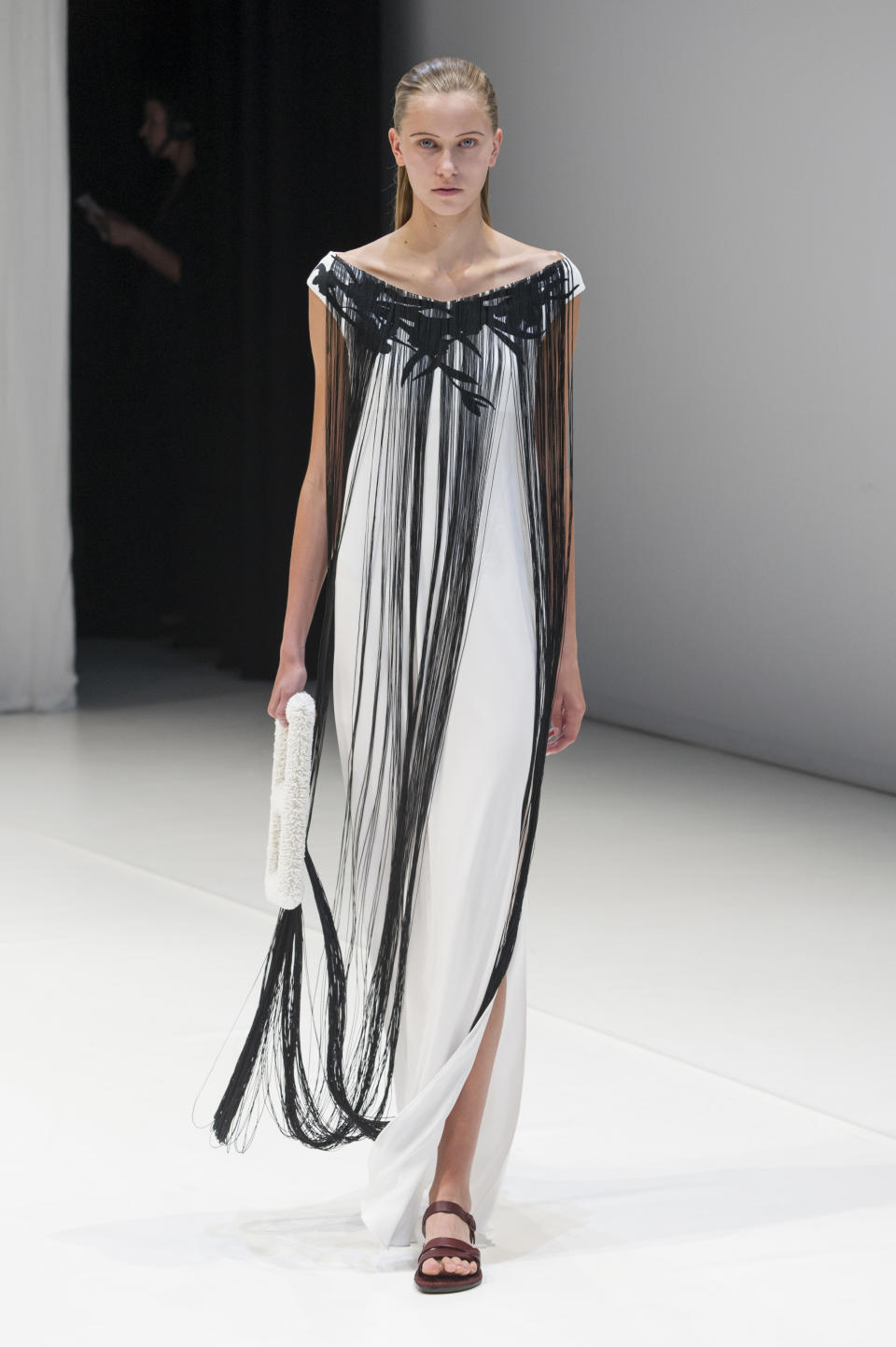<p><i>White maxi dress with extra-long black-fringed collar from the SS18 Hussein Chalayan collection. (Photo: IMAXtree) </i></p>