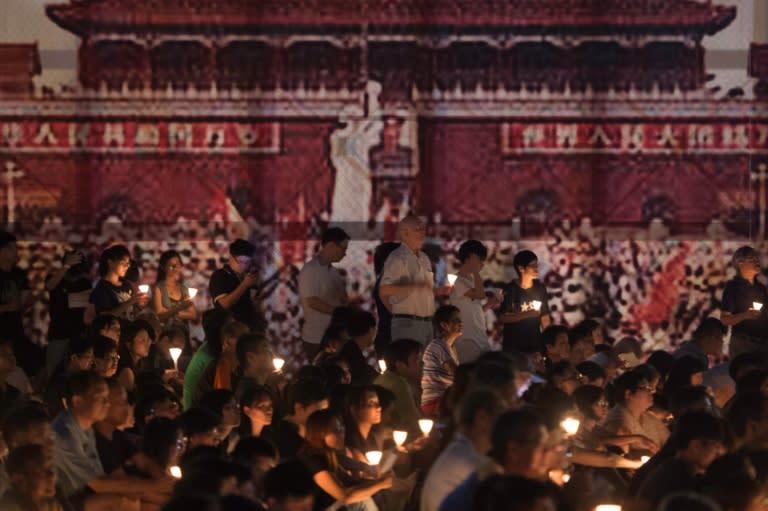 Participants hold candles during a vigil for the 27th anniversary of the 1989 Tiananmen Square crackdown, at Victoria Park in Hong Kong on June 4, 2016