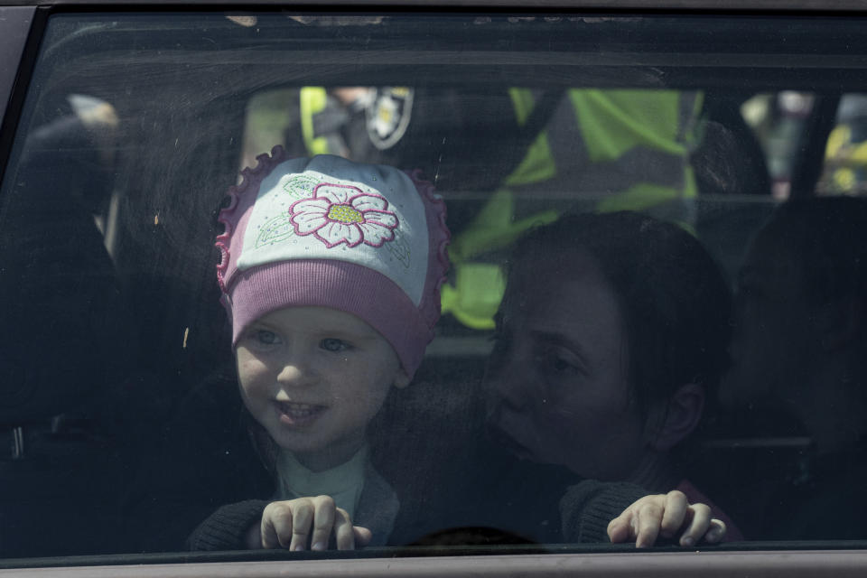 A girl looks through the window of a car as her family arrives from Mariupol at the center for displaced people in Zaporizhia, Ukraine, Thursday, May 5, 2022. (AP Photo/Evgeniy Maloletka)
