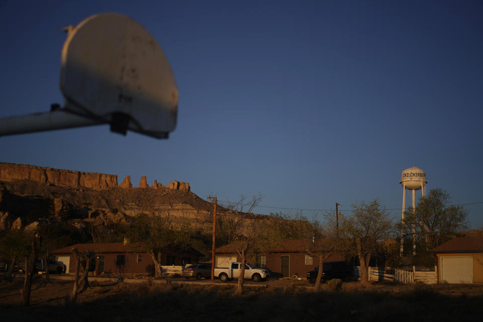 FILE - In this Sunday, April 19, 2020, file photo, the water tower and a basketball backboard at the school in Chilchinbeto, Ariz., on the Navajo reservation, are seen at sunrise. Basketball is woven in the fabric of Native American life. Now, during a global pandemic, the balls have all but stopped bouncing. Already hit hard by the coronavirus outbreak, Native Americans are faced with life without basketball — or any other sport - for the forseeable future. (AP Photo/Carolyn Kaster, File)