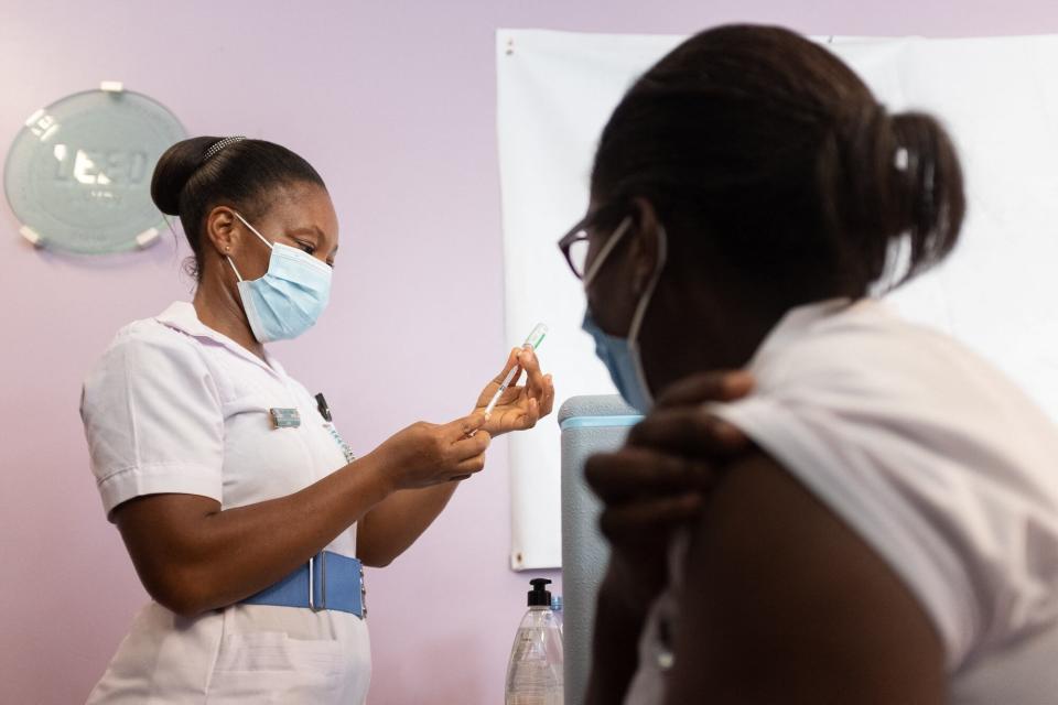 GHANA: Una trabajadora de la salud se prepara para vacunar a una enfermera de primera línea con la vacuna Oxford / AstraZeneca en el Hospital Ridge en Accra, Ghana, el 2 de marzo de 2021.