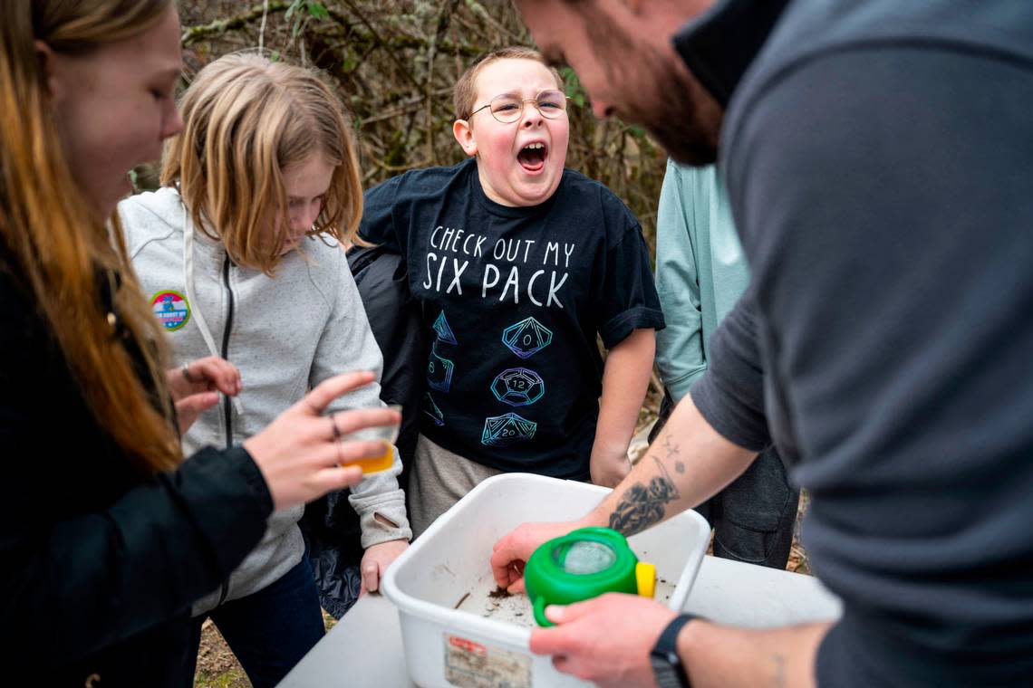 Grant Elementary School fifth grader Marshall Carleton, 10, screams as he sees a bug being picked up at Swan Creek Park during a school field trip that is part of the Foss Waterway Seaport Salmon in the Classroom program, in Tacoma on March 15, 2023.