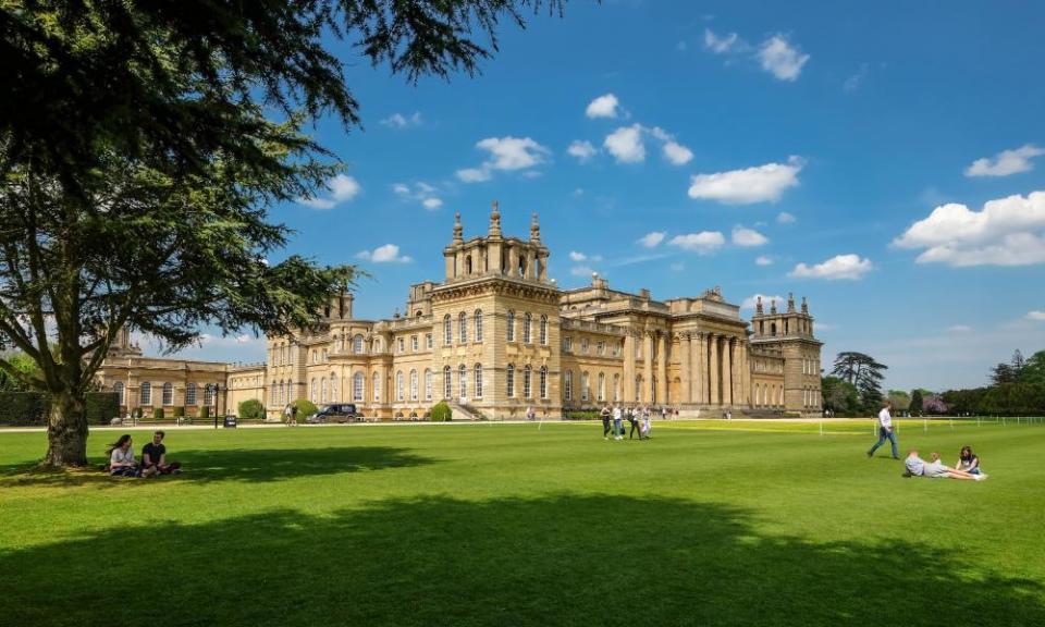 Blenheim Palace visitors relaxing on the lawn on a sunny day. The historic venue will host drive-in movies this summer.