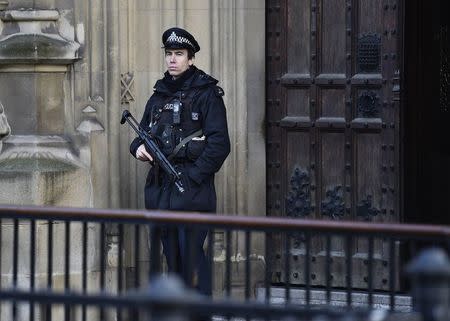 An armed police officer guards outside of the Houses of Parliament in central London, November 24, 2014. REUTERS/Toby Melville