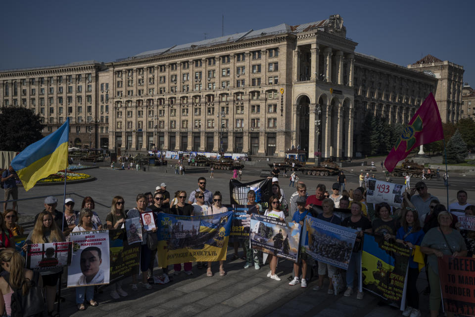 People gather for a protest calling for the release of Ukrainian soldiers captured by Russians while Russian tanks are on display in the background at the Independence Square in Kyiv, Ukraine, Sunday, Aug. 27, 2023. The protest marks five hundred days since the soldiers were captured in the besieged city of Mariupol. (AP Photo/Bram Janssen)