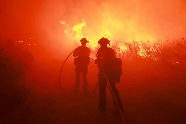 Des pompiers californiens luttent contre le "Post Fire", dans une région rurale au nord-ouest de Los Angeles, le 16 juin 2024 (DAVID SWANSON)