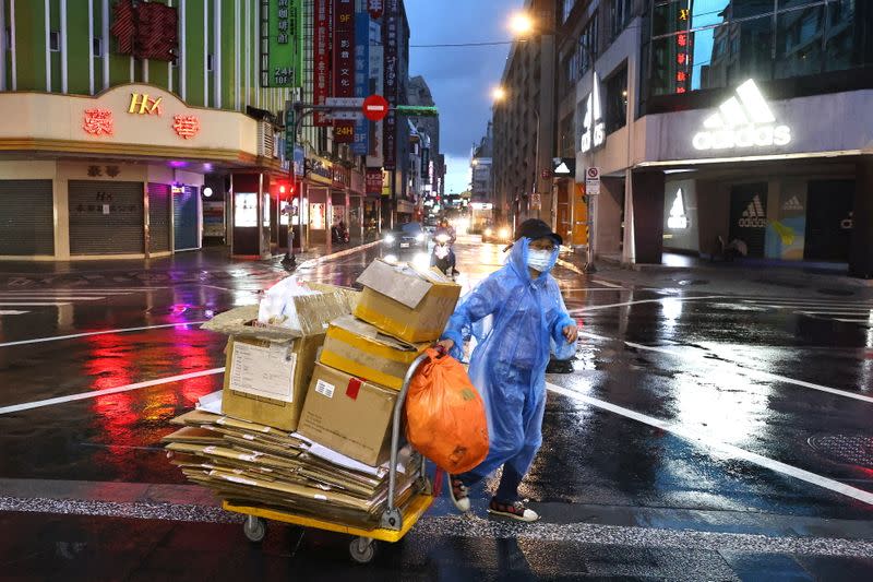 A woman crosses the street while wearing a protective mask following the recent rise in coronavirus disease (COVID-19) infections in Taipei