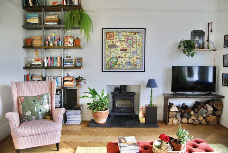 Living room with a lounge chair, fireplace, and floor-to-ceiling bookshelf.