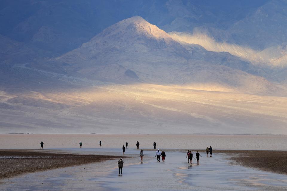 Tourists enjoy the rare opportunity to walk in water Sunday as they visit Badwater Basin, normally the driest place in the United States, in Death Valley National Park. The lowest point in North America, the basin was flooded by Hurricane Hilary in August and recent rains in California.