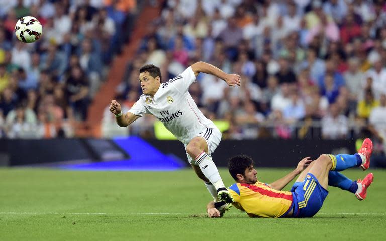 Real Madrid's Mexican forward Javier Hernandez (L) vies with Valencia's defender Antonio Barragan Fernandez during the Spanish league football match in Madrid on May 9, 2015