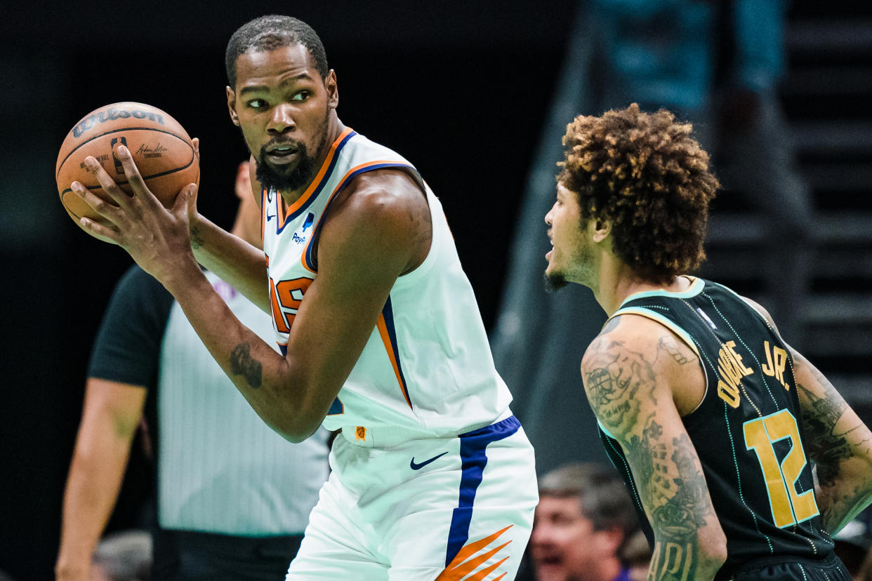 CHARLOTTE, NORTH CAROLINA - MARCH 01: Kelly Oubre Jr. #12 of the Charlotte Hornets guards Kevin Durant #35 of the Phoenix Suns in the third quarter during their game at Spectrum Center on March 01, 2023 in Charlotte, North Carolina. NOTE TO USER: User expressly acknowledges and agrees that, by downloading and or using this photograph, User is consenting to the terms and conditions of the Getty Images License Agreement. (Photo by Jacob Kupferman/Getty Images)