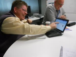 Guy laughing and pointing at laptop screen