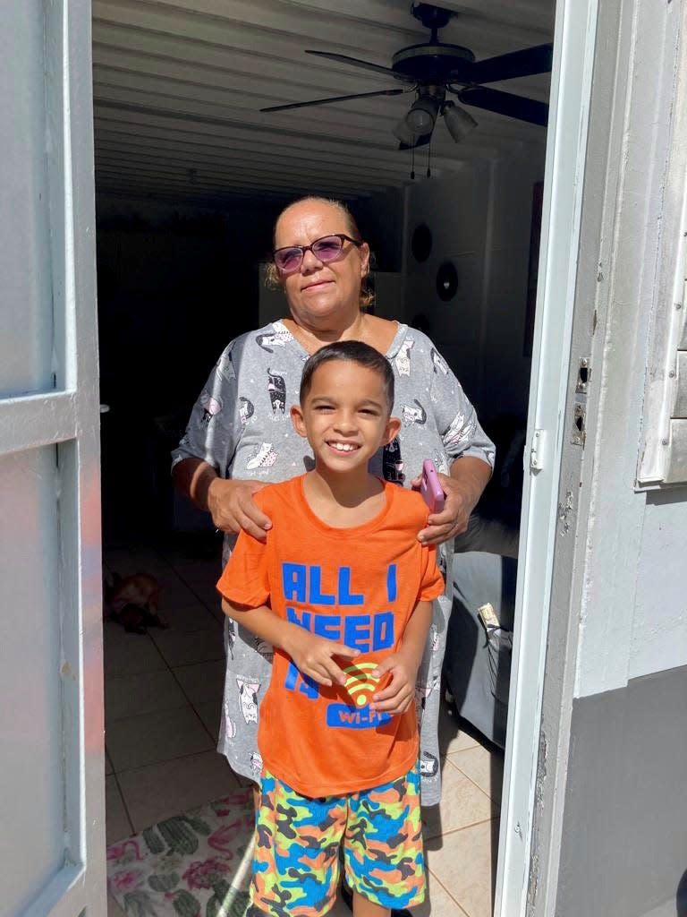 Nereida Rivera, 60, stands with her grandson, Jayden Ramos, 8, on Wednesday in the Ariel neighborhood of Comerío, Puerto Rico. Their apartment building is near the Rio de la Plata, which flooded this week during Hurricane Fiona.