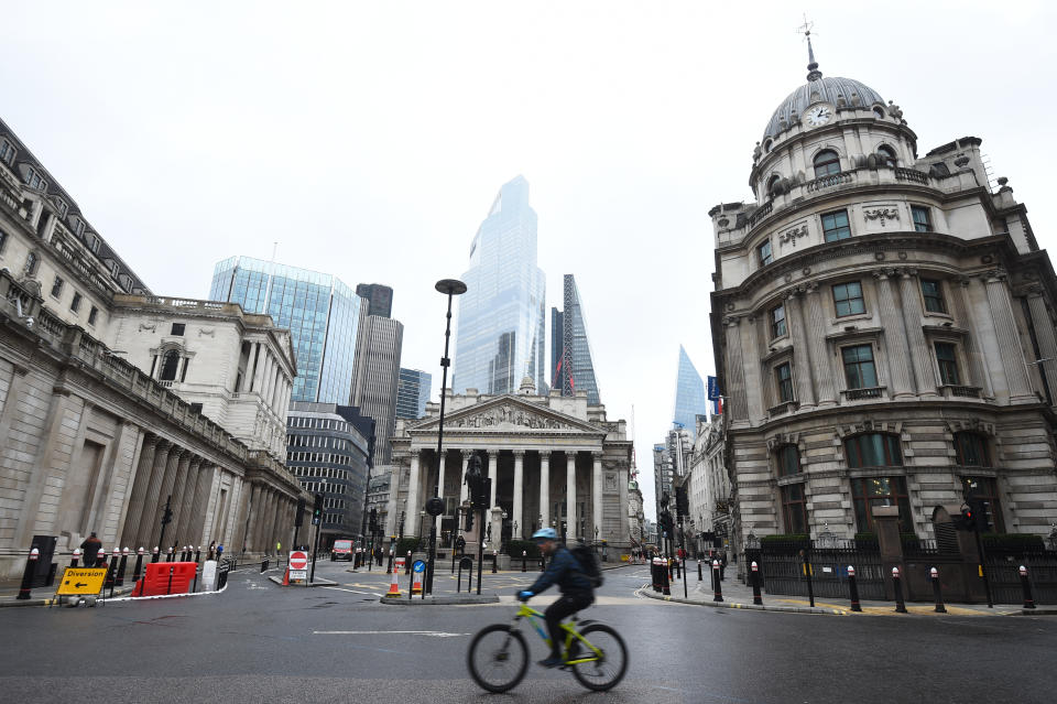 A man cycles past the Bank of England and the Royal Exchange in the City of London. (Photo by Kirsty O'Connor/PA Images via Getty Images)