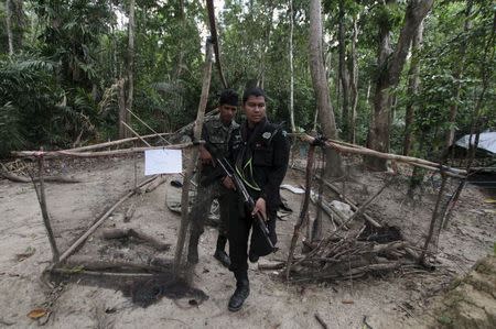 Security forces inspect an abandoned camp at a rubber plantation near a mountain in Thailand's southern Songkhla province May 7, 2015. REUTERS/Surapan Boonthanom