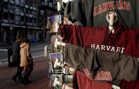 FILE PHOTO: People walk past Harvard University t-shirts for sale in Harvard Square in Cambridge, Massachusetts, U.S. on November 16, 2012.  REUTERS/Jessica Rinaldi/File Photo