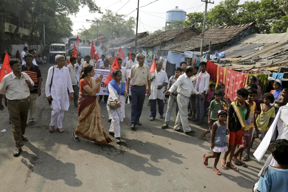 Communist Party of India (Marxist) candidate Nandini Mukherjee, fourth from left with folded hands, seeks votes in a slum area in Kolkata, India, Thursday, April 10, 2014. Millions of people are voting in the third phase of the elections Thursday, covering parts of 11 of India's 28 states. The multiphase voting across the country runs until May 12, with results for the 543-seat lower house of parliament announced May 16. (AP Photo/Bikas Das)