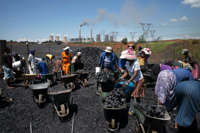 Women from Masakhane settlement fill their wheel barrows with free coal provided by the nearby mine in Emalahleni