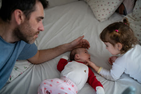 Adi, 37, who works for a removal company, spends time with his daughters, Elena, who is two years and seven-months old, and baby Ioana who is a few weeks old, at their home in London, Britain, February 22, 2019. REUTERS/Alecsandra Dragoi