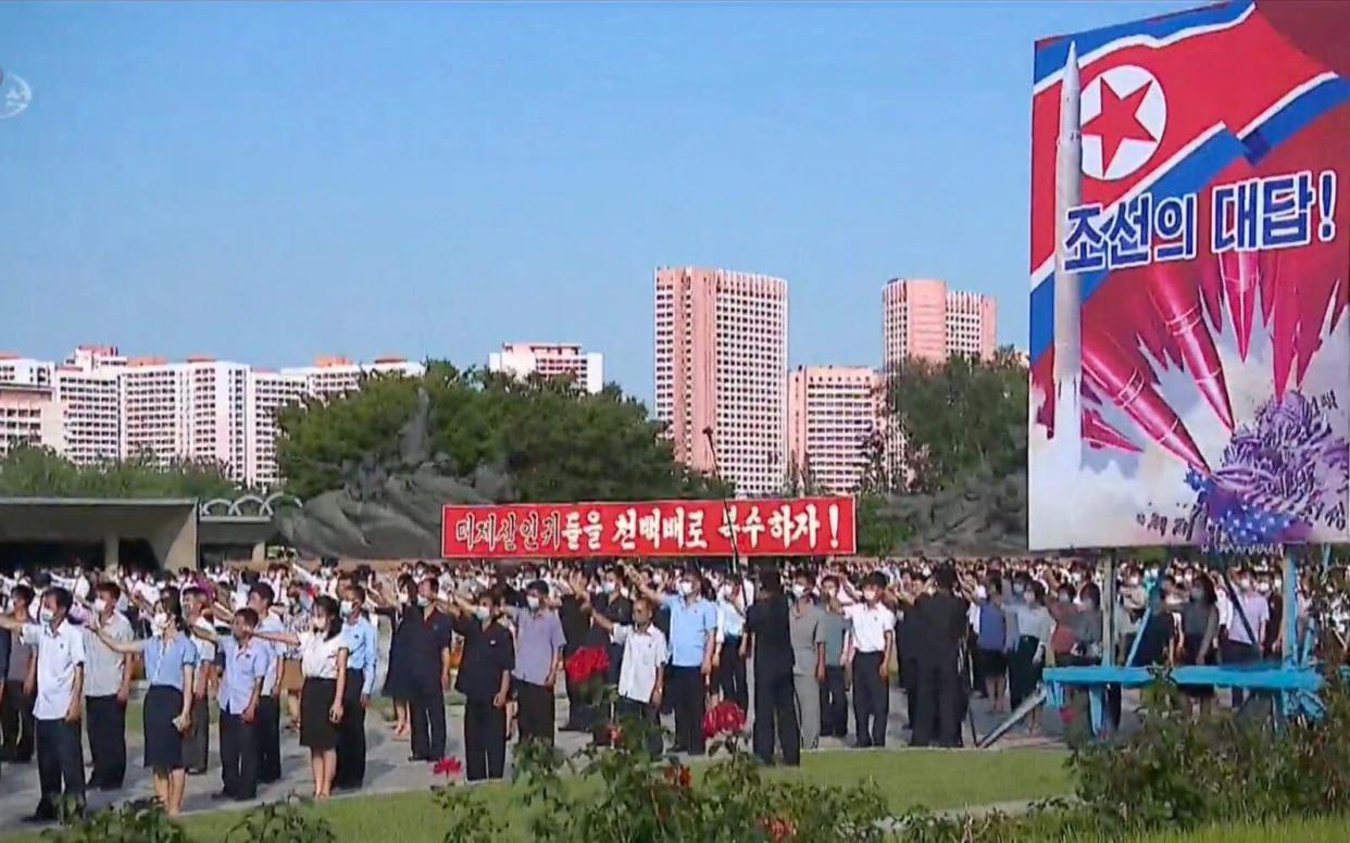 An old anti-U.S. propaganda poster depicting nuclear attack on Washington appears at a rally in June 2022 - KCTV