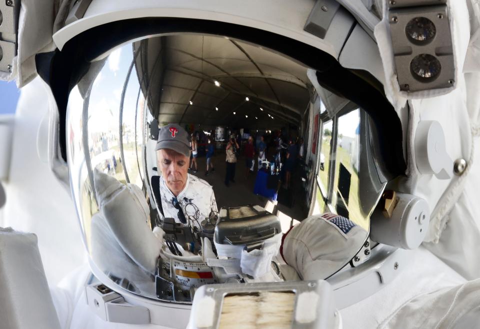 Chuck MacArthur from Florida looks over a space suit in the NASA building at EAA AirVenture Oshkosh 2022, Monday, July 25, 2022, in Oshkosh, Wis.