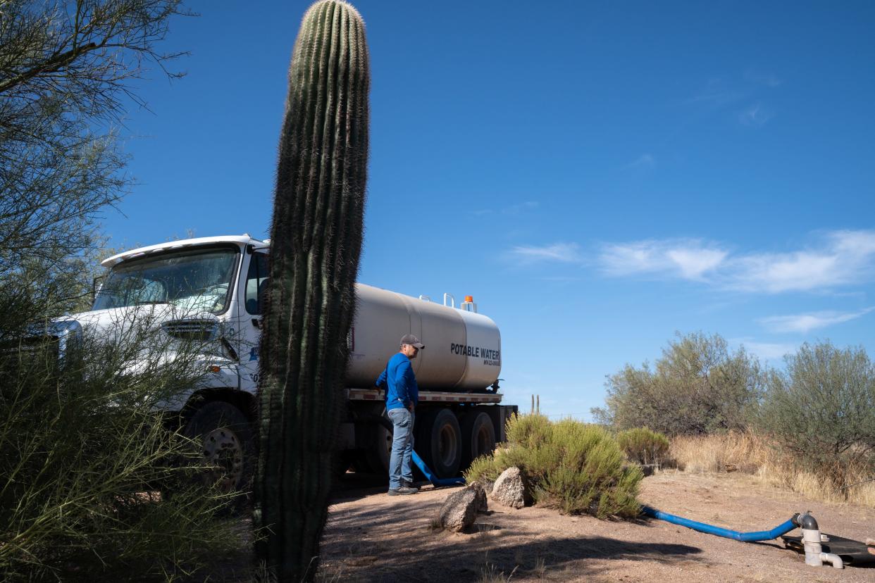 Fabian Lache (Rio Verde Foothills Potable Water Hauling, Inc.) unloads water from his truck into an underground storage tank, October 10, 2023, at a home in the Rio Verde Foothills, Arizona.