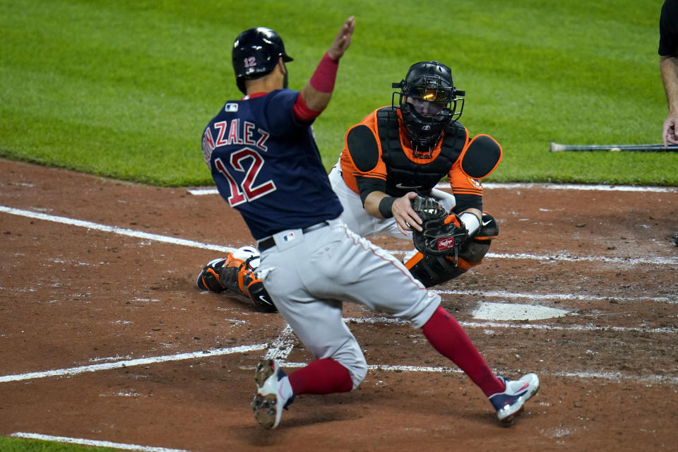 Baltimore Orioles catcher Chance Sisco, right, prepares to tag out Boston Red Sox's Marwin Gonzalez at home during the fourth inning of a baseball game, Saturday, April 10, 2021, in Baltimore. Gonzalez was trying to score on a hit by Christian Arroyo. (AP Photo/Julio Cortez)