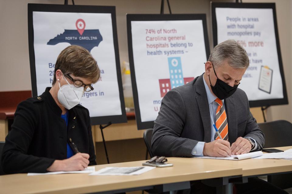 North Carolina Attorney General Josh Stein and Senator Julie Mayfield take notes during a meeting with elected officials, medical professionals and community members April 28 at Buncombe Health and Human Services about the impact of HCA Healthcare's 2019 acquisition of Mission Hospital.