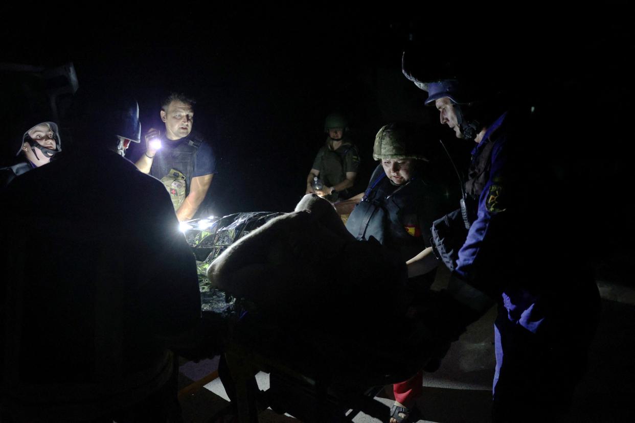 Responders check on a casualty (AFP via Getty Images)