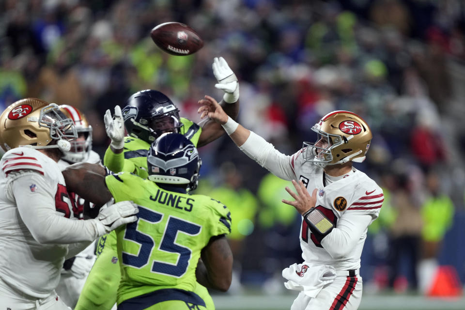 San Francisco 49ers quarterback Brock Purdy throws to wide receiver Brandon Aiyuk for a 28-yard touchdown during the second half of an NFL football game against the Seattle Seahawks, Thursday, Nov. 23, 2023, in Seattle. (AP Photo/Stephen Brashear)