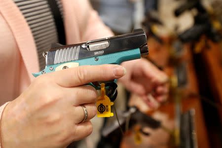 A woman looks over a semi-automatic handgun Kimber Micro Bel Air, a .380 ACP caliber, during the SHOT (Shooting, Hunting, Outdoor Trade) Show in Las Vegas, Nevada, U.S., January 22, 2019. Picture taken January 22, 2019. REUTERS/Steve Marcus