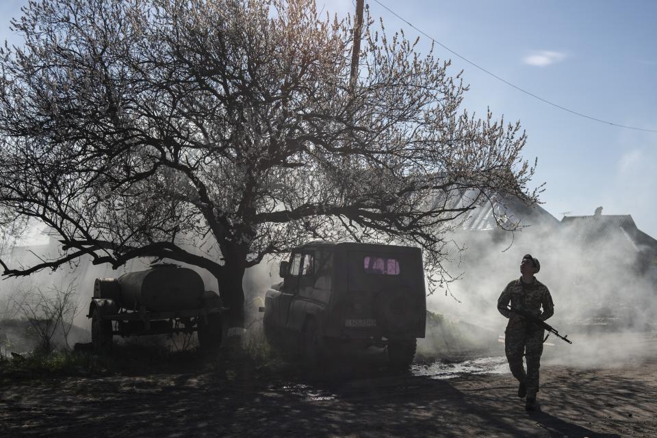 FILE - In this file photo taken on Saturday, April 20, 2019, a Ukrainian serviceman guards a position near the front line as the conflict continues, in Mariinka, Donetsk region, eastern Ukraine. Ukraine's president sits down Monday, Dec. 9, 2019 for peace talks in Paris with Russian President Vladimir Putin in their first face-to-face meeting, and the stakes could not be higher. More than five years of fighting in eastern Ukraine between government troops and Moscow-backed separatists has killed more than 14,000 people, and a cease-fire has remained elusive. (AP Photo/Evgeniy Maloletka, File)